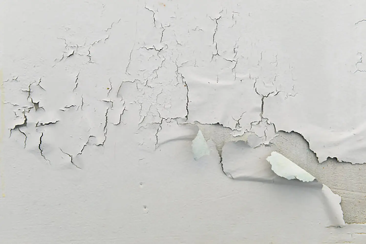Peeling paint on an interior wall showing when peeling paint signals a bigger interior issue due to underlying wall damage